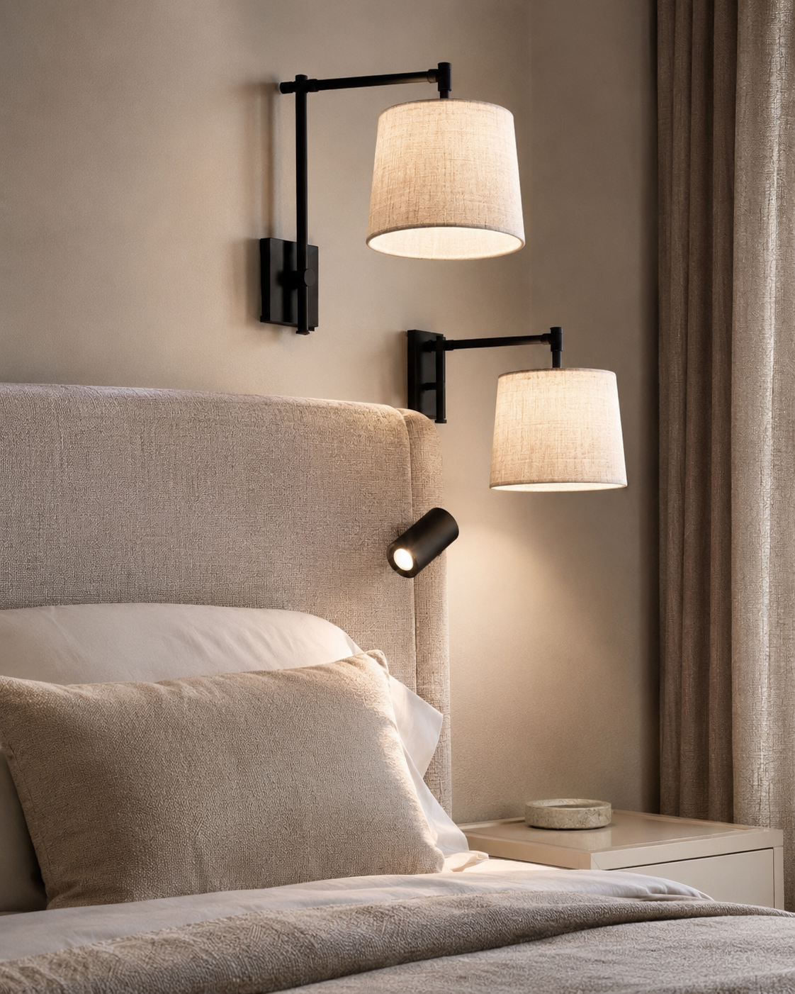 Neutral bedroom with black swing arm wall sconces, focused reading light, upholstered headboard, and soft bedding.