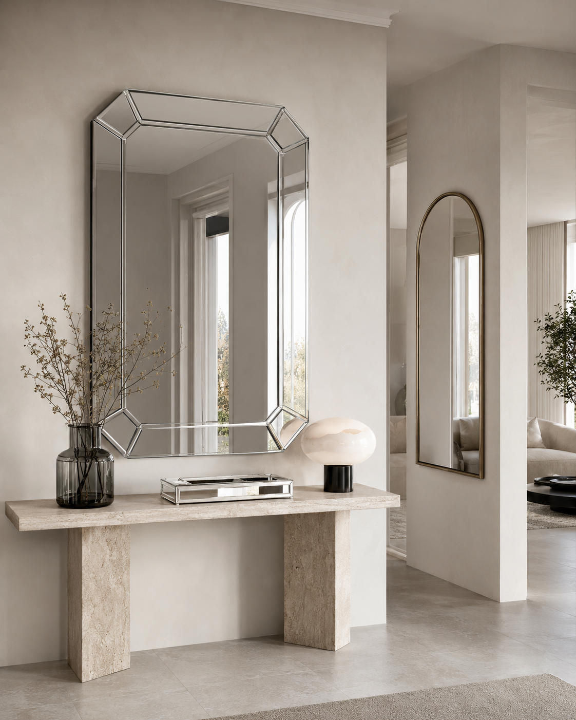 Geometric silver mirror above a pale stone entryway console