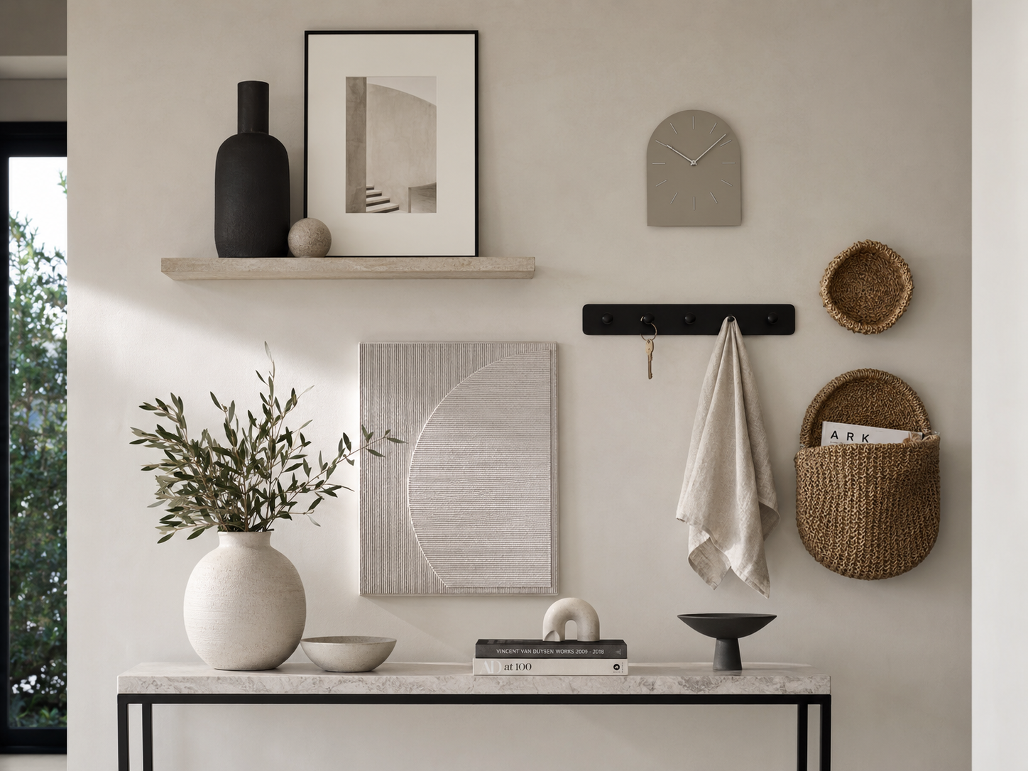 Curated entryway wall with abstract art, floating shelf, clock, peg rail and decorative woven baskets
