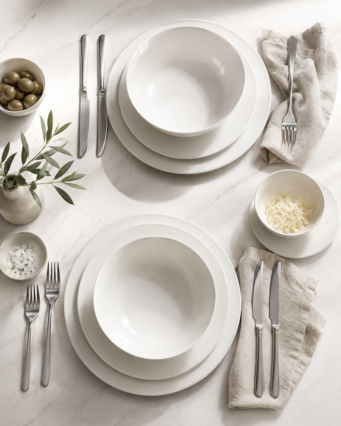 Everyday neutral table setting with matte dinner plates pasta bowls cereal bowls and stainless flatware