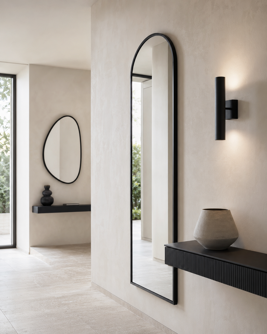 Tall black arched full-length mirror beside a floating entryway console