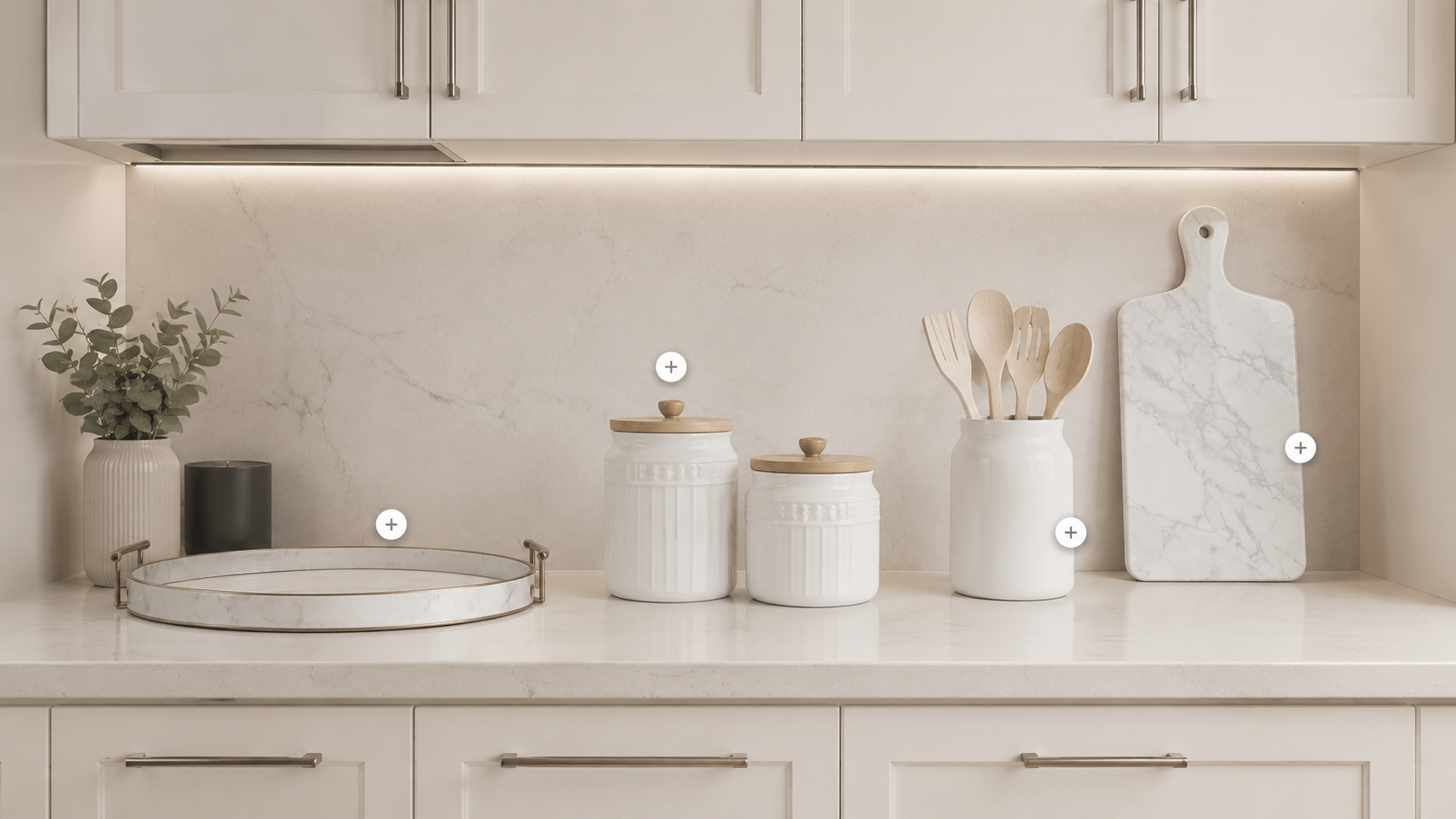 Kitchen counter decor with tray, ceramic canisters, utensil holder, and marble board in a neutral kitchen