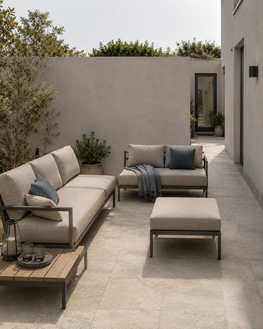 Neutral outdoor sofas and modular lounge seating arranged beside a clear side passage in a compact courtyard