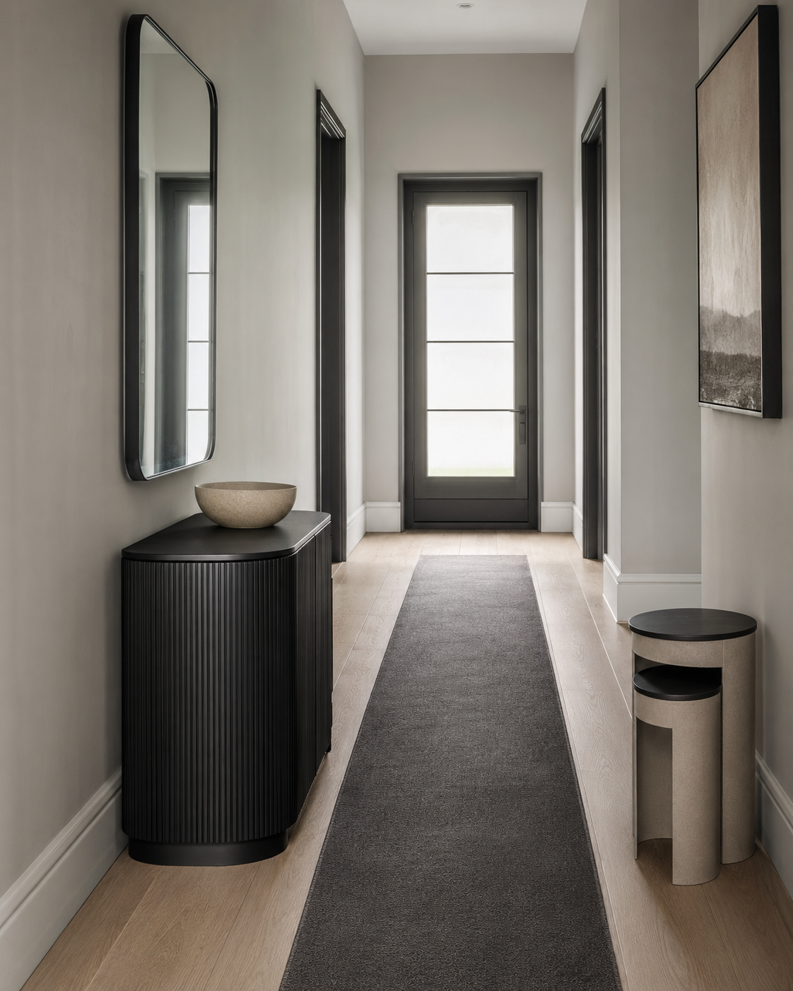 Narrow hallway with a black fluted console, compact side tables and gray runner