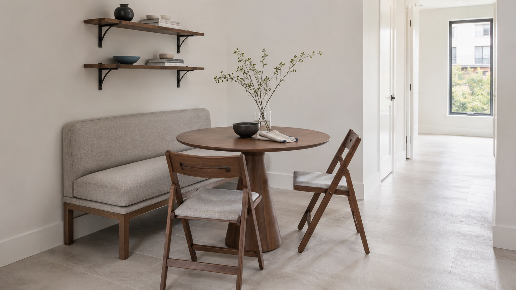 Small dining room solutions with a round pedestal table, upholstered bench, folding chairs and floating wall shelves