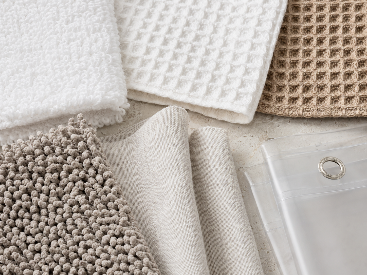 Close editorial view of layered bathroom towel textures and textile surfaces.