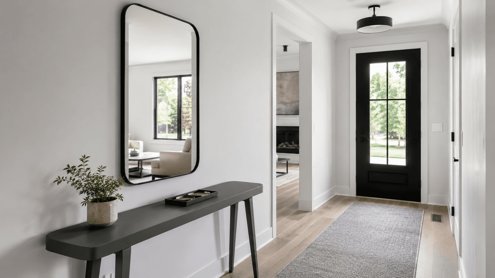 Entryway Mirrors - Ravnora Decor Contemporary entryway with a large black mirror, slim console and clear circulation to the front door
