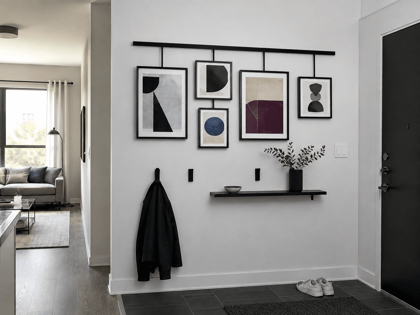 Gallery-led entryway with a controlled frame arrangement, low-profile hooks and a shallow landing surface