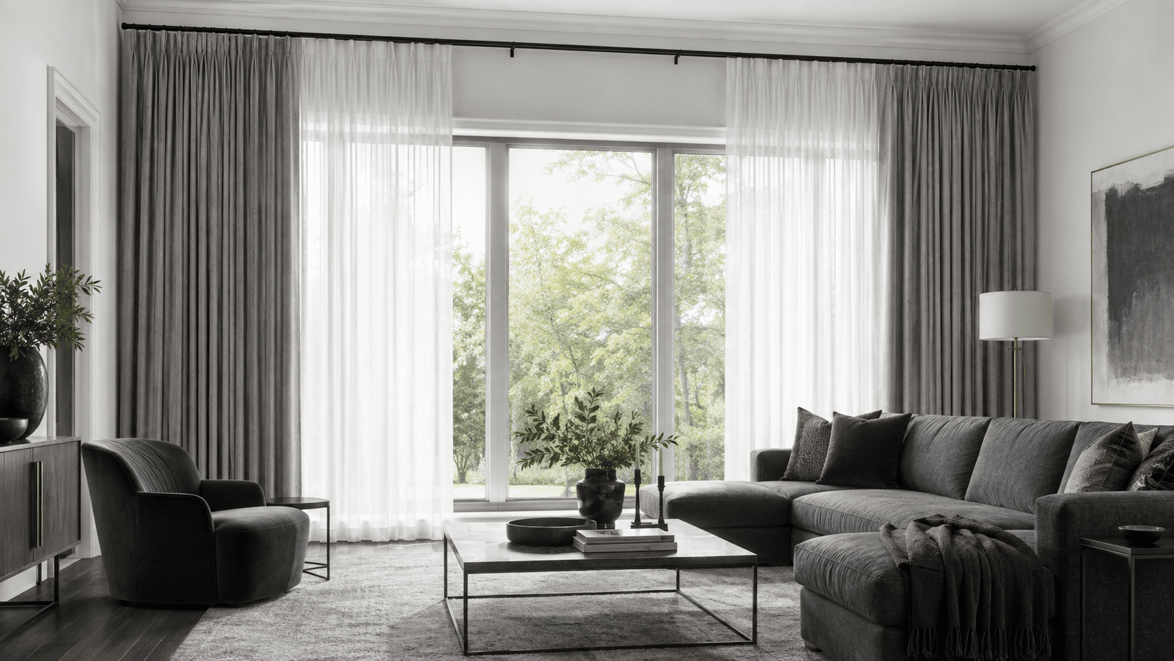 Wide living room window wall with layered white sheers, full gray curtains and black hardware mounted above the frame