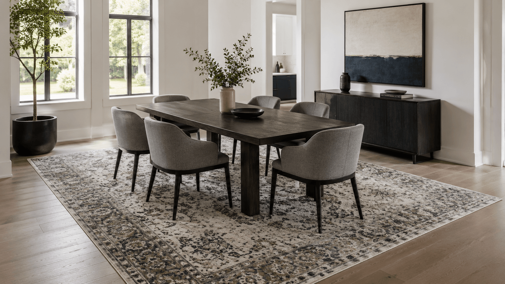 Dining Room Rugs - Ravnora Decor Contemporary rectangular dining table centered on a large rug with room for chairs to pull back.