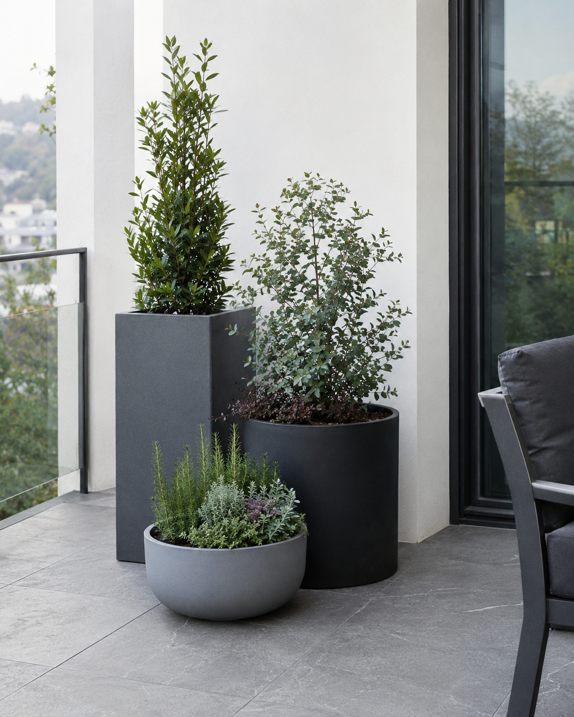 Three modern outdoor floor planters in staggered heights create a composed balcony corner without crowding the walkway.