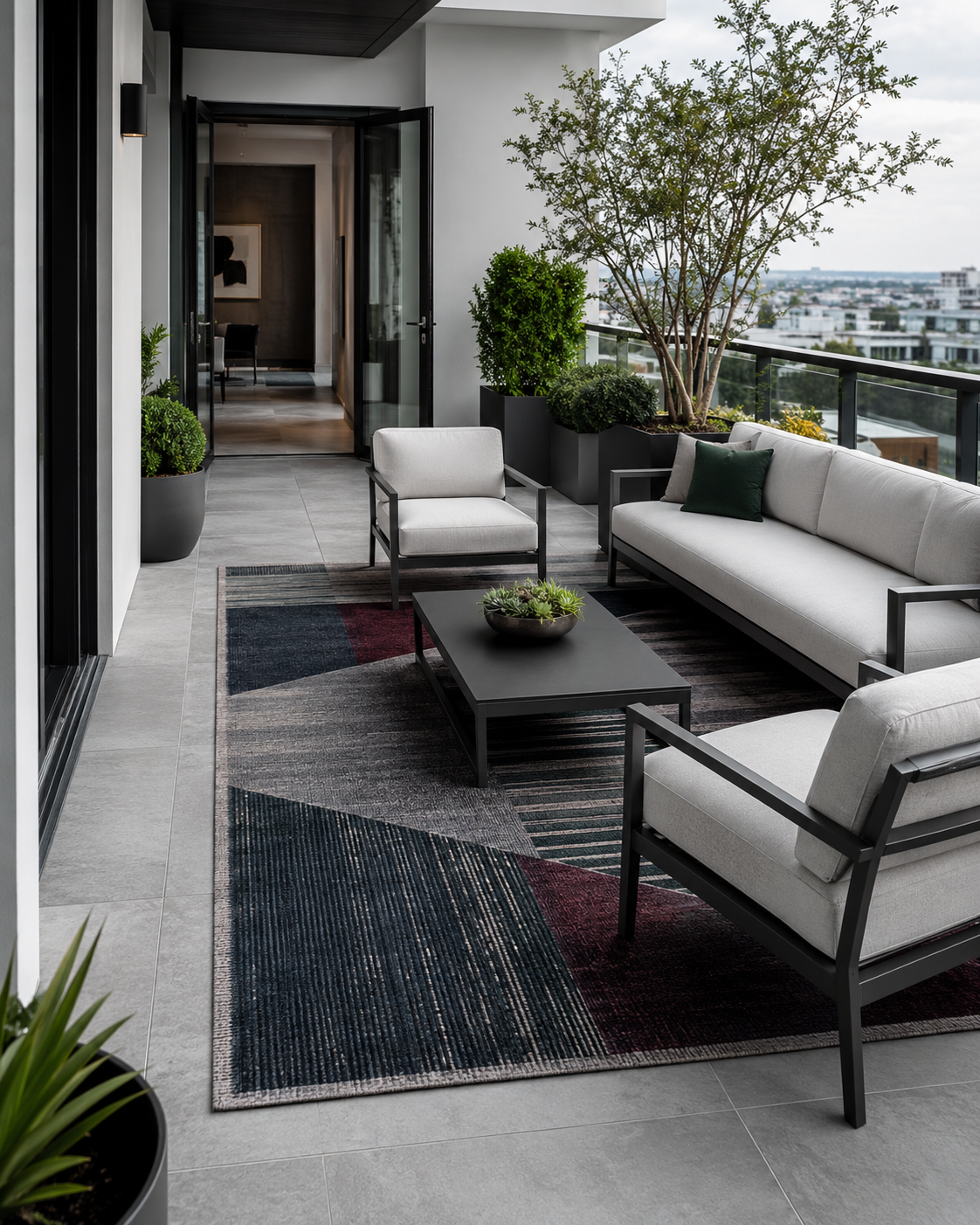 Modern cool-toned outdoor lounge with a large patterned rug connecting the seating while maintaining an open path