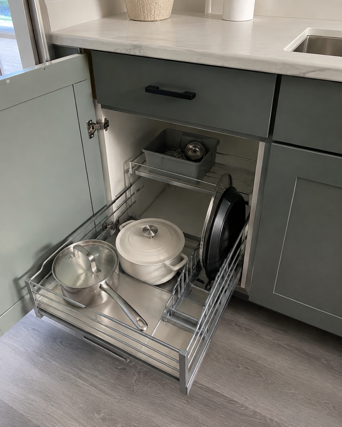 Compact kitchen with a slim rolling cart beside the refrigerator, showing narrow parked storage and the surrounding walkway