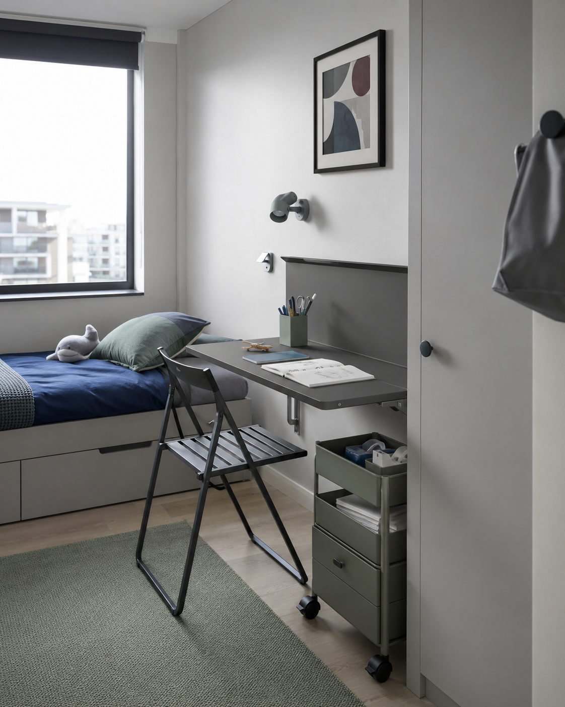 Small Kids Room Solutions - Ravnora Decor Compact kids study zone using a wall-side folding desk, slim folding chair and narrow rolling storage beside the bed.
