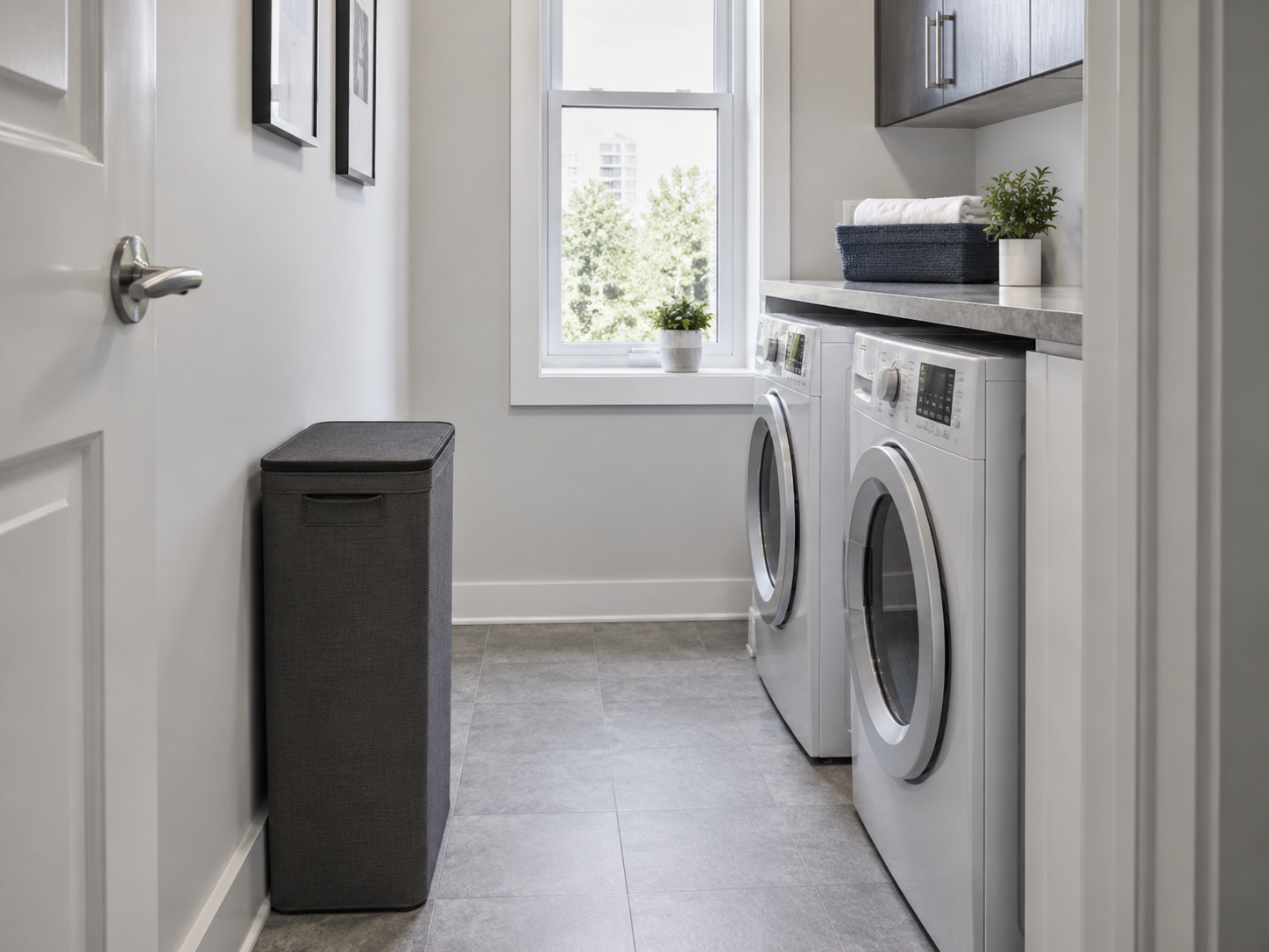 Laundry Hampers - Ravnora Decor Slim lidded hamper placed along a compact galley laundry wall while the center walkway remains clear.