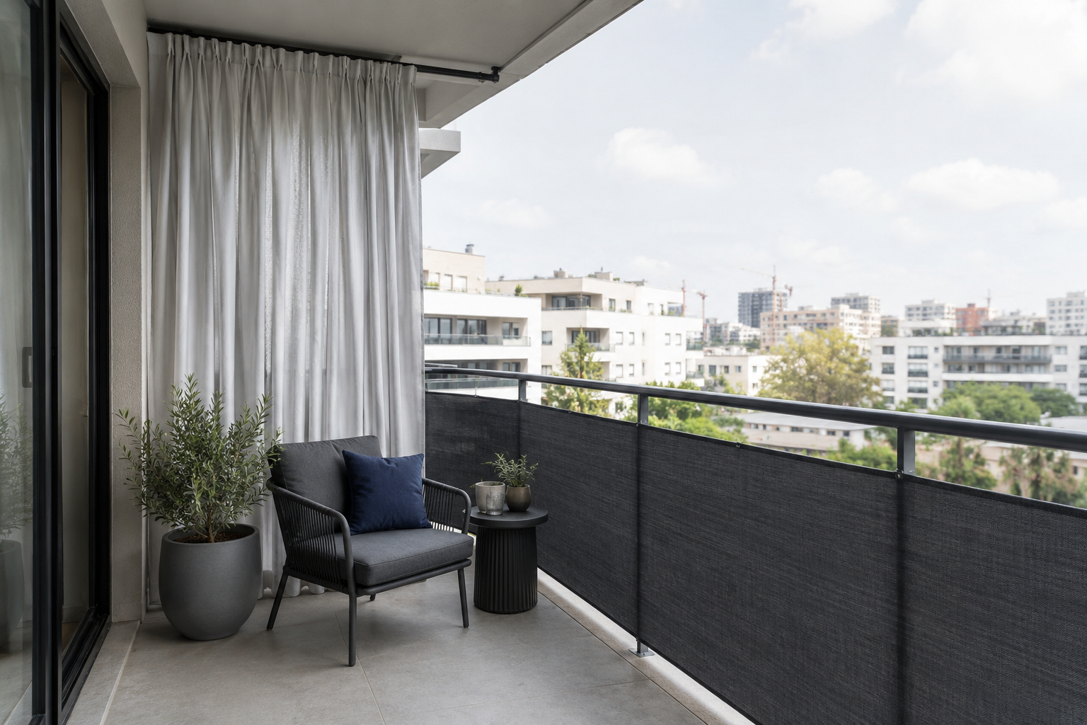 Sheltered apartment balcony with pale supported privacy curtain, charcoal railing screen and compact dark seating.