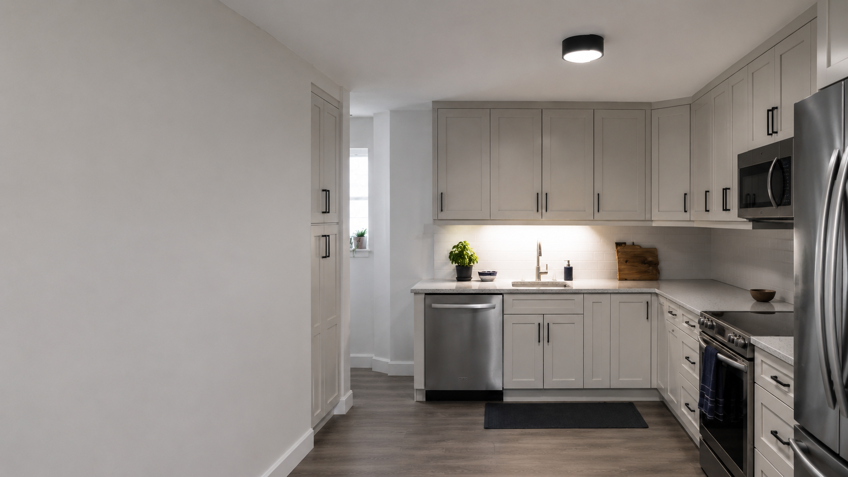 Contemporary kitchen where general room lighting leaves one work counter dark while another counter receives useful task lighting.