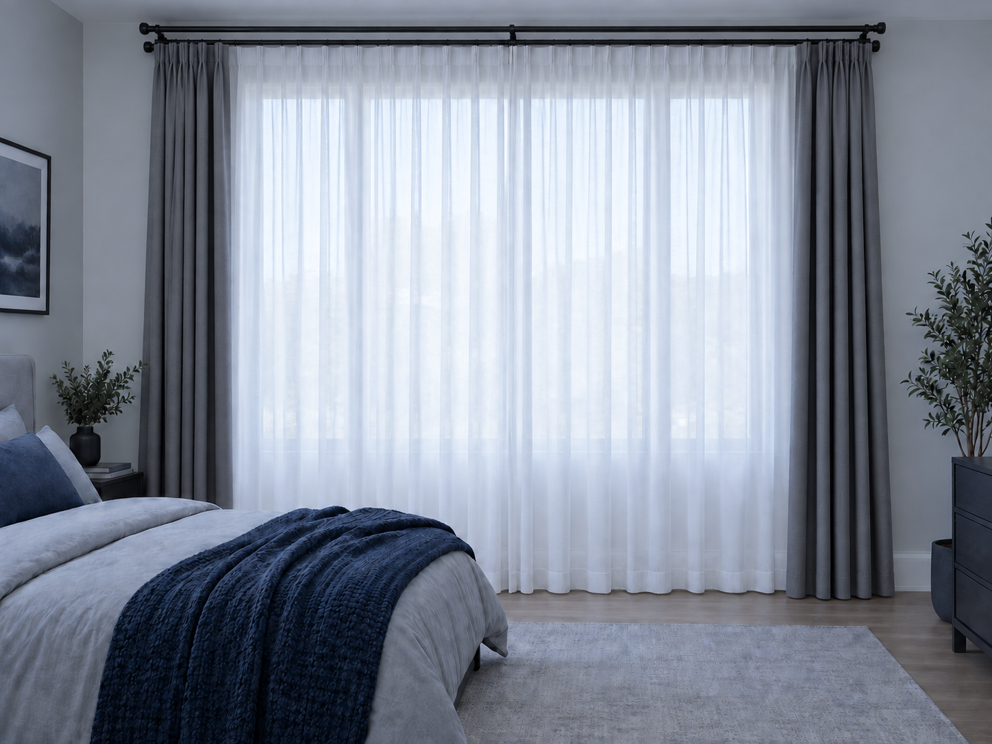 Layered bedroom window with white sheers behind open floor-length outer curtains.