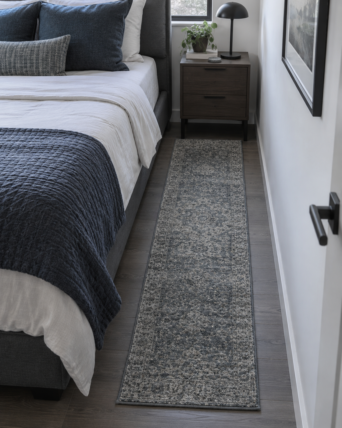 Compact bedroom using a narrow bedside runner to create a soft landing where a full under-bed rug would crowd the room.