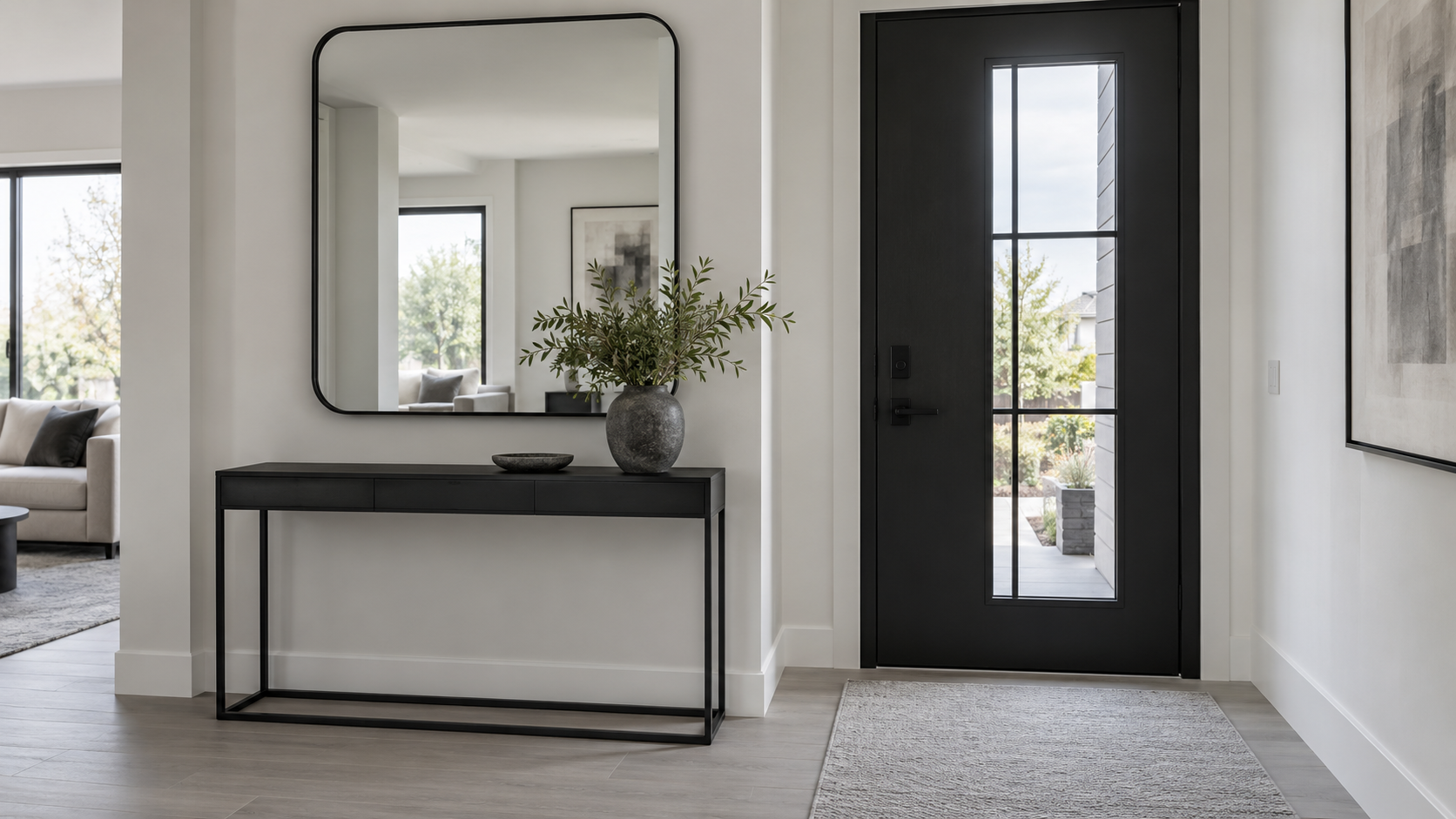Entryway Mirrors - Ravnora Decor Resolved contemporary entryway with a correctly scaled black mirror above a slim console, calm reflected daylight and a clear path to the front door