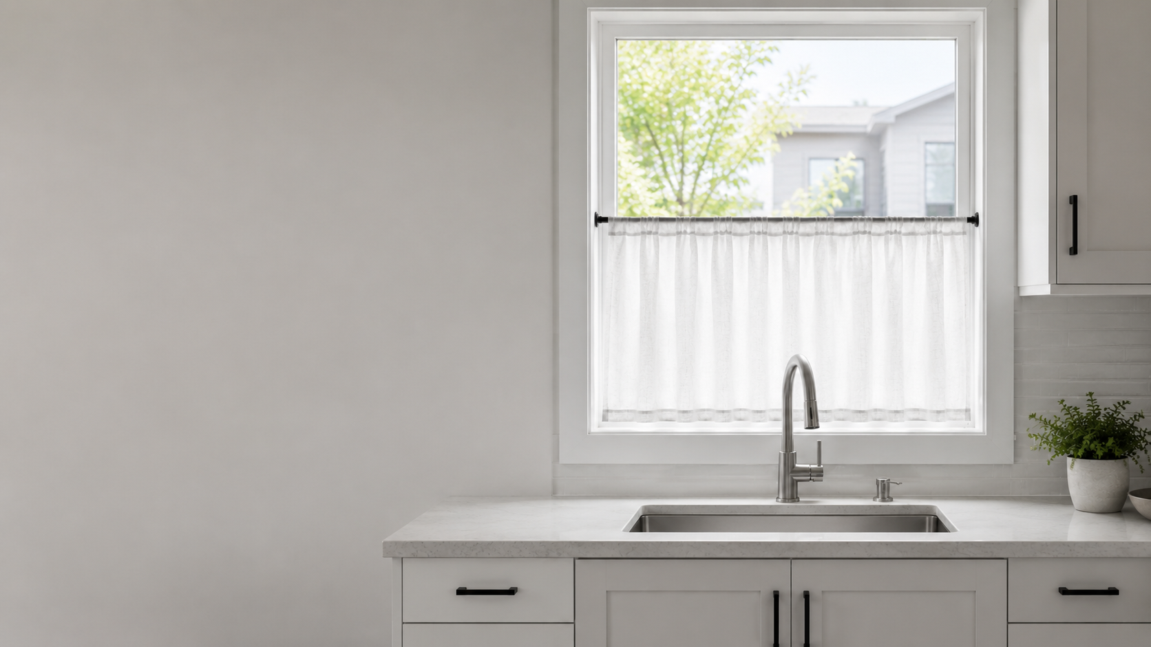 Kitchen Curtains & Window Styling - Ravnora Decor Contemporary kitchen sink window with a white café curtain covering only the lower half for privacy while the upper glass remains open to daylight.