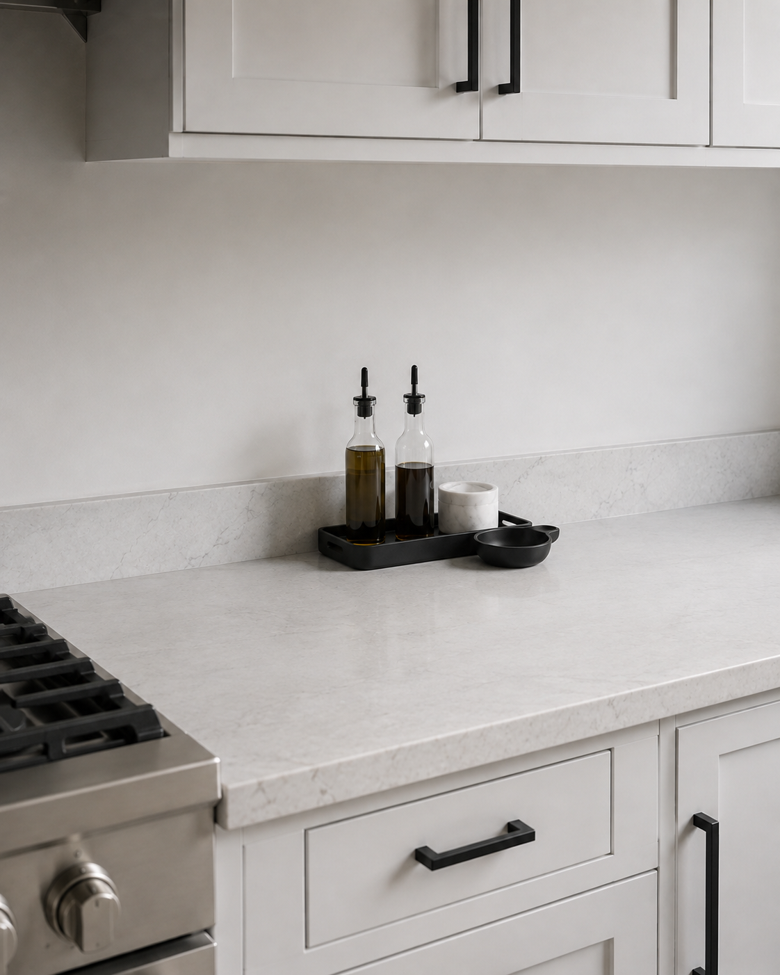 Kitchen Counter Decor - Ravnora Decor Compact oil, salt and spoon-rest station positioned beyond a clear buffer from the cooktop with open prep space beside it.