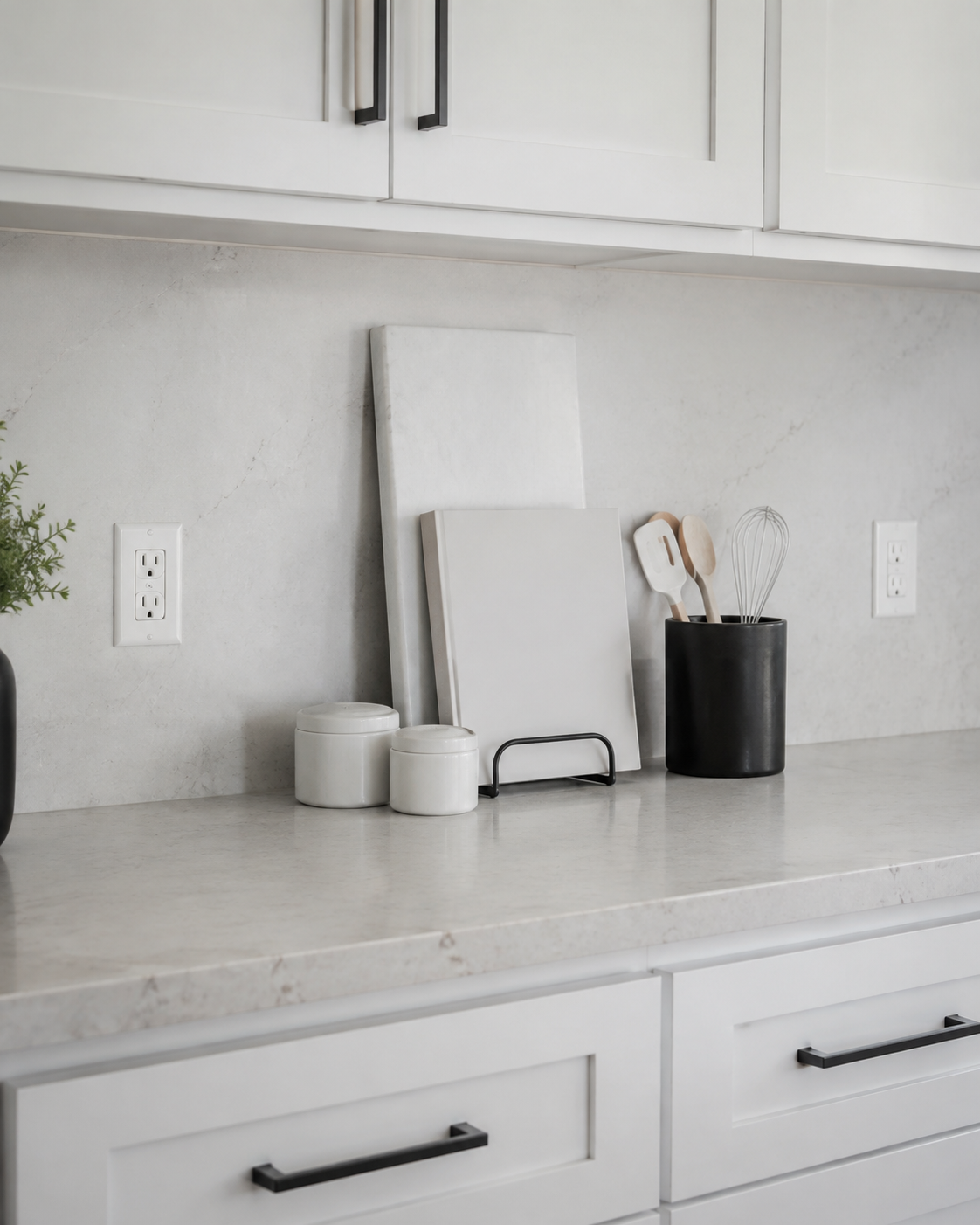 Kitchen Counter Decor - Ravnora Decor Back kitchen counter with a slim pale stone board, cookbook stand, canisters and utensil crock arranged as a compact vertical layer.