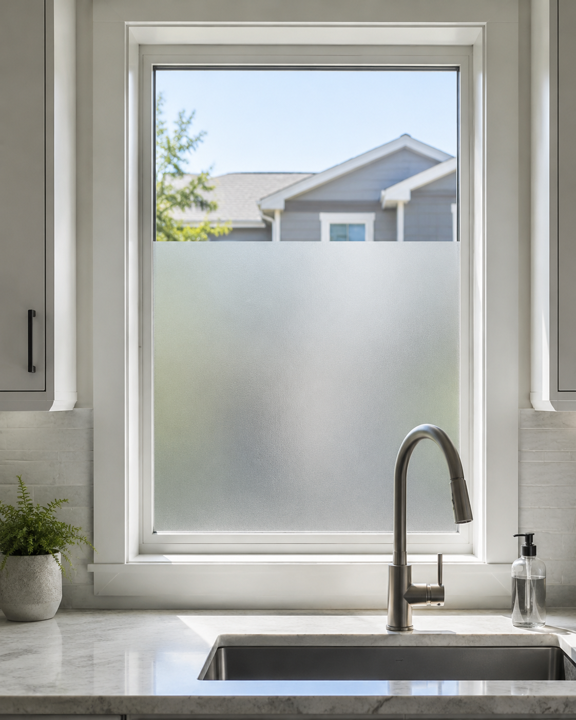 Kitchen Curtains & Window Styling - Ravnora Decor Kitchen window with plain frosted privacy film covering the lower sightline while the upper glass remains clear.