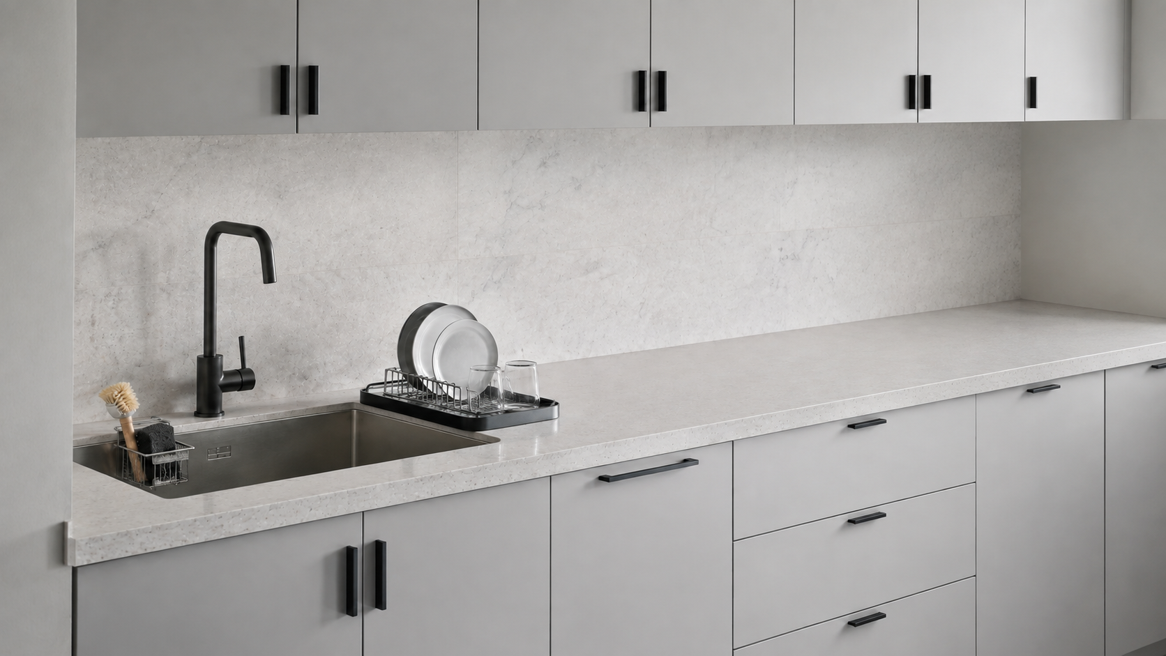 Kitchen sink with a compact caddy and bounded dish-drying area beside a protected clear countertop span.