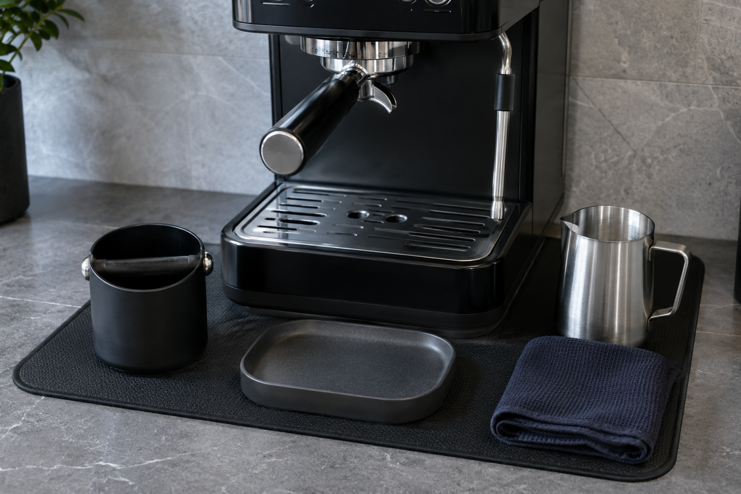 Coffee-machine reset zone with defined mat, tray and espresso cleanup accessories.