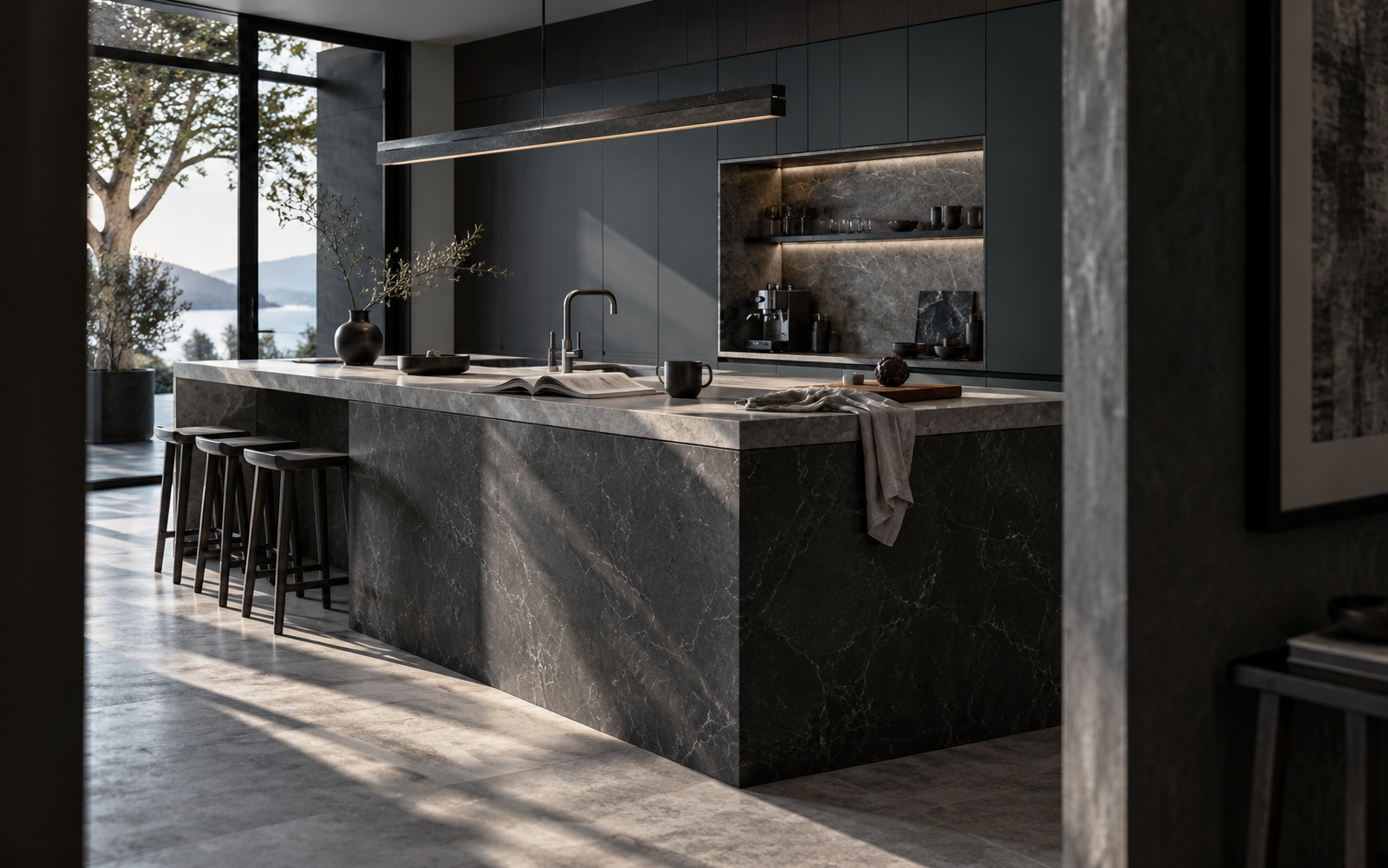 Dramatic contemporary kitchen with a dark stone island, integrated cabinetry and directional morning light.
