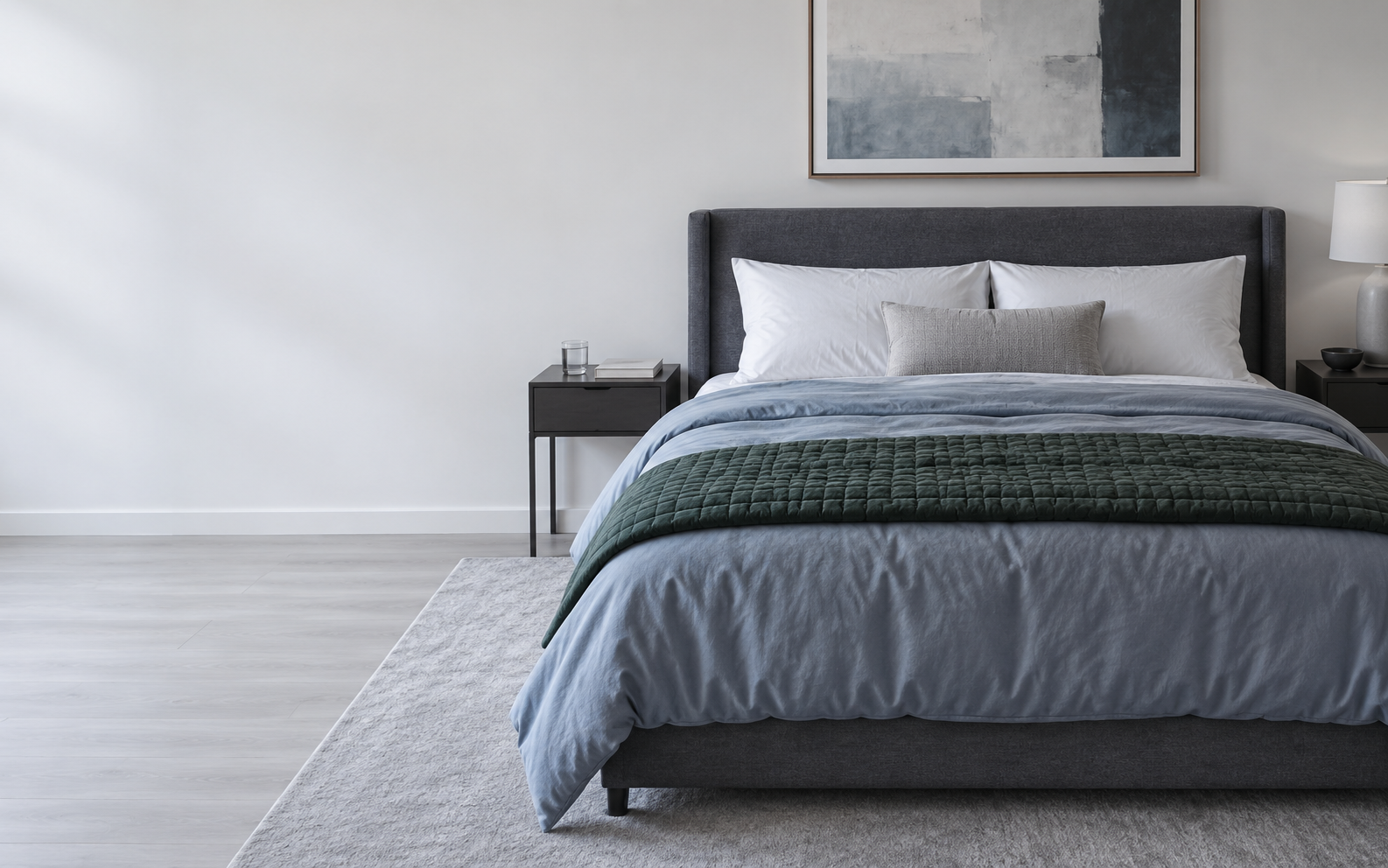 Cool contemporary bedroom with layered white, blue-gray and muted green bedding in natural daylight.