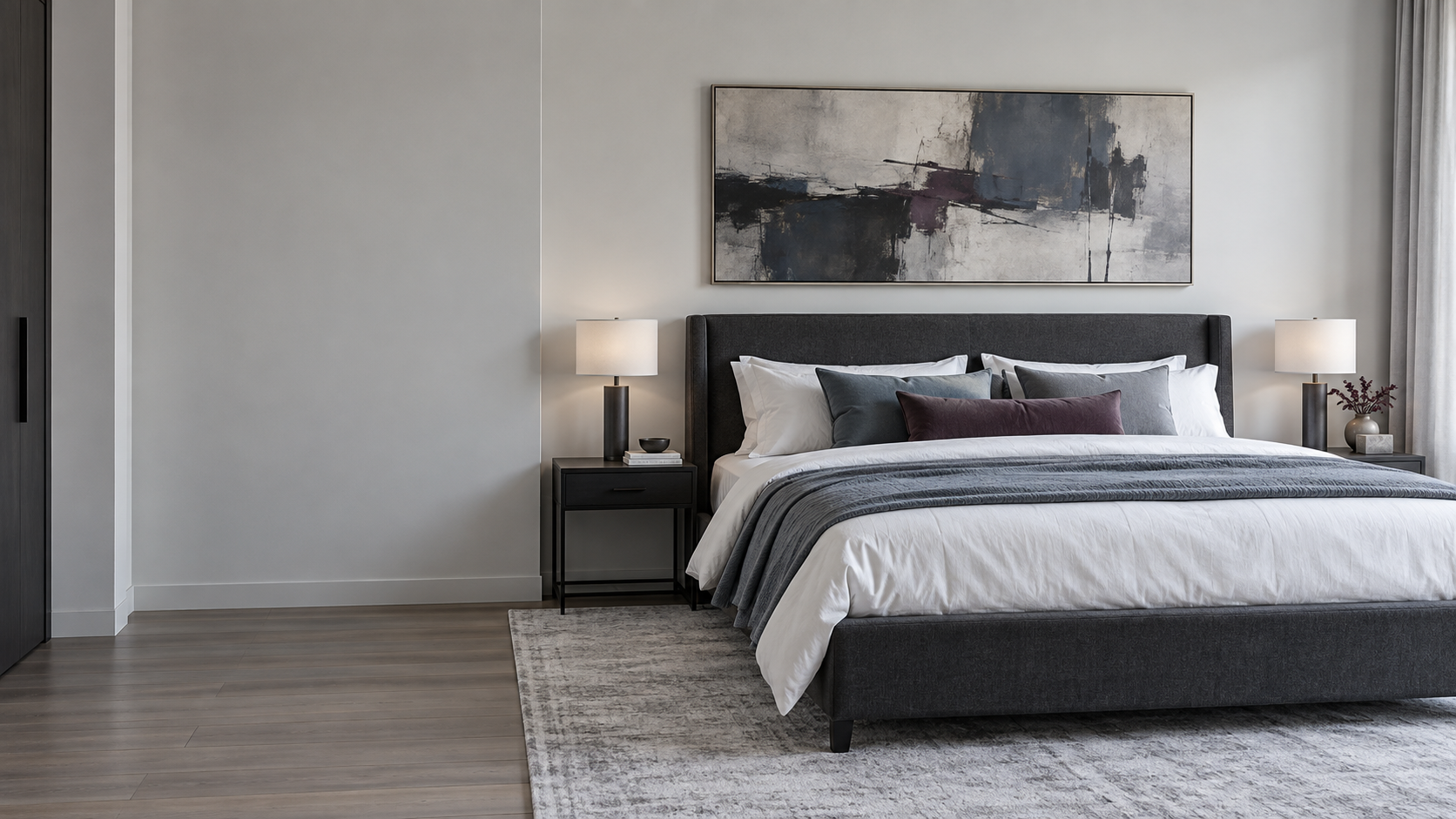 Contemporary bedroom with properly scaled abstract artwork visually connected to a charcoal upholstered bed.